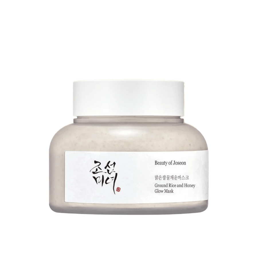Nádoba "Beauty of Joseon Ground Rice and Honey Glow Mask". Balenie je jednoduché s bielym uzáverom a etiketou, ktorá predstavuje názov produktu a ingrediencie v kórejčine aj angličtine. Produkt je navrhnutý tak, aby pokožke dodal lesk a výživu.