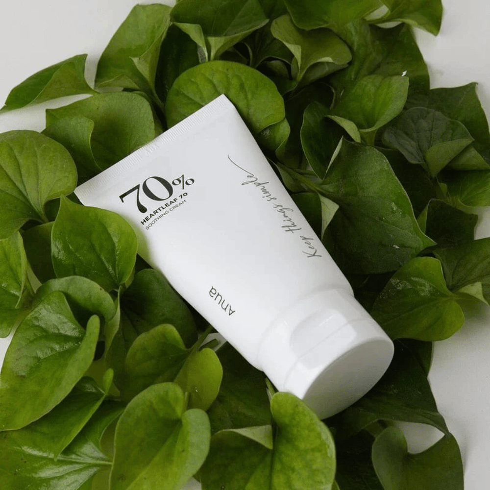 Tuba Heartleaf 70% Soothing Cream spočíva na posteli zo zelených listov.