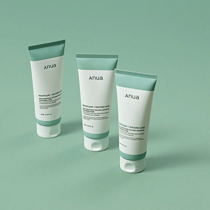 Tri balenia Anua Heartleaf + Succinic Acid Moisture Cleansing Foam prezentované na svetlozelenom pozadí. Obrázok zdôrazňuje čistý a minimalistický dizajn produktu a zároveň vytvára profesionálny dojem z produktového radu.
