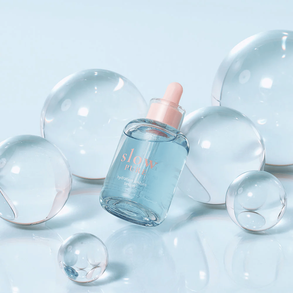 Slow Pure Hydration Texture Serum umiestnené medzi priehľadnými bublinami, symbol intenzívnej hydratácie.