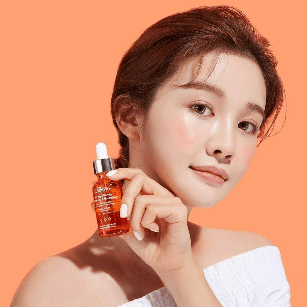 Žena držiaca fľašu JUMISO All Day Vitamin Brightening & Balancing Facial Serum 30ml.