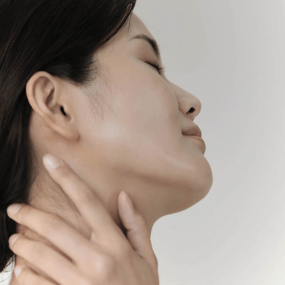 Žena ukazuje svoju upokojenú, hydratovanú pleť po použití Celimax Ji Woo Gae Cica BHA Blemish Toner Pad.