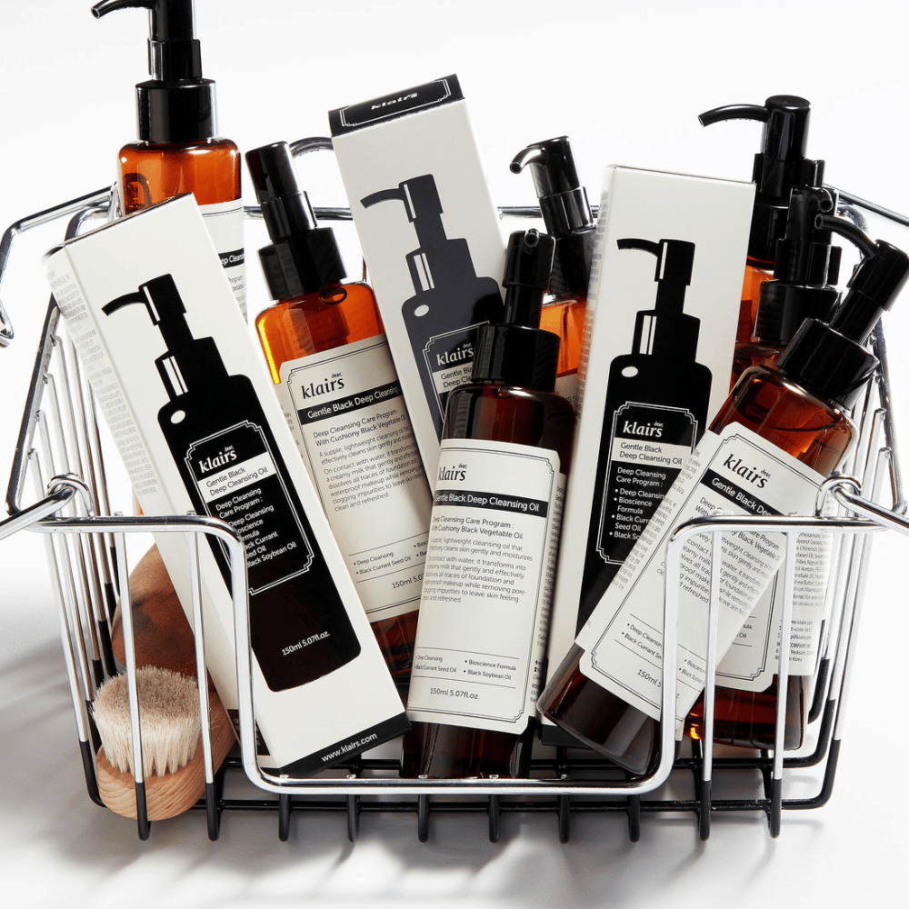 Mini nákupný vozík plný produktov starostlivosti o pleť od Klairs, vrátane Gentle Black Deep Cleansing Oil v priehľadných fľašiach s čiernymi pumpami a zodpovedajúcimi obalmi.