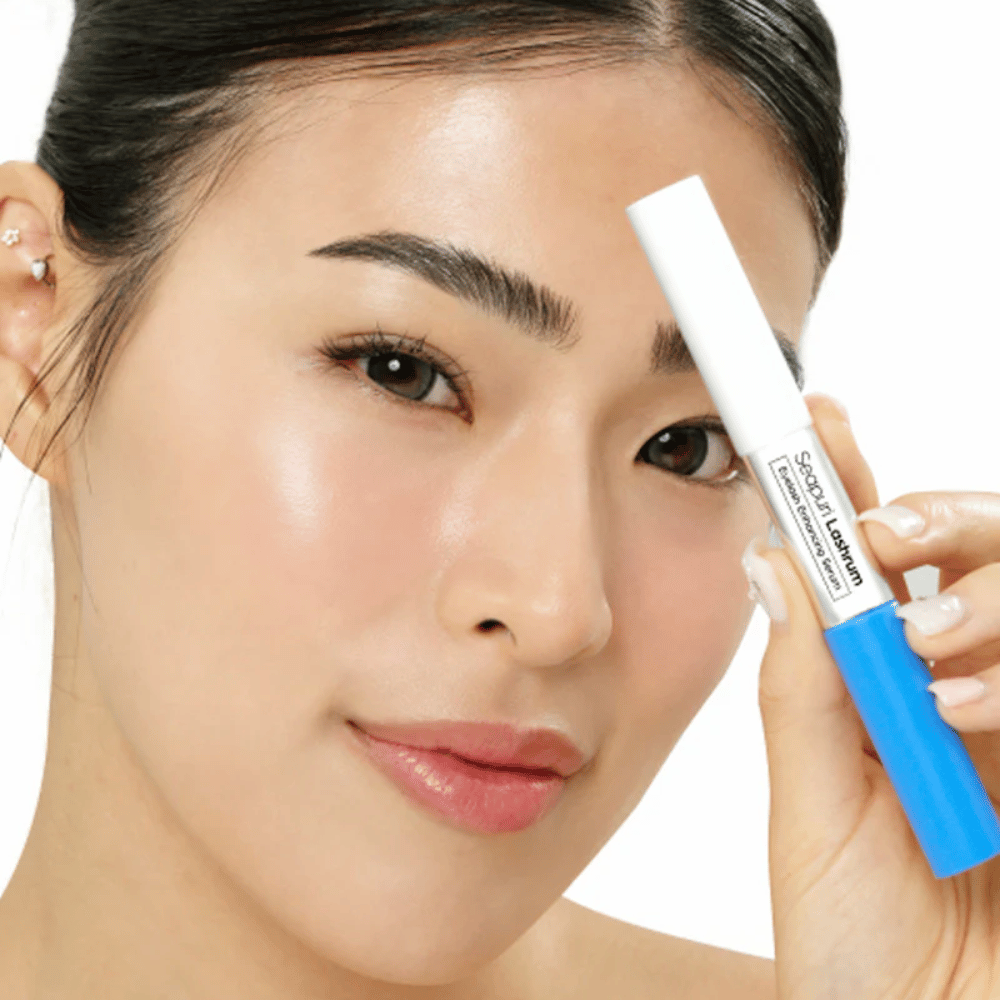 Žena drží Seapuri Lashrum Eyelash Enhancing Serum. Ošetrujúce sérum na riasy, ktoré posilňuje a definuje riasy.