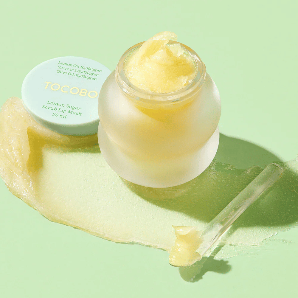 Otvorená nádoba s Tocobo Lemon Sugar Scrub Lip Mask na zelenom pozadí, s jasne viditeľným obsahom.