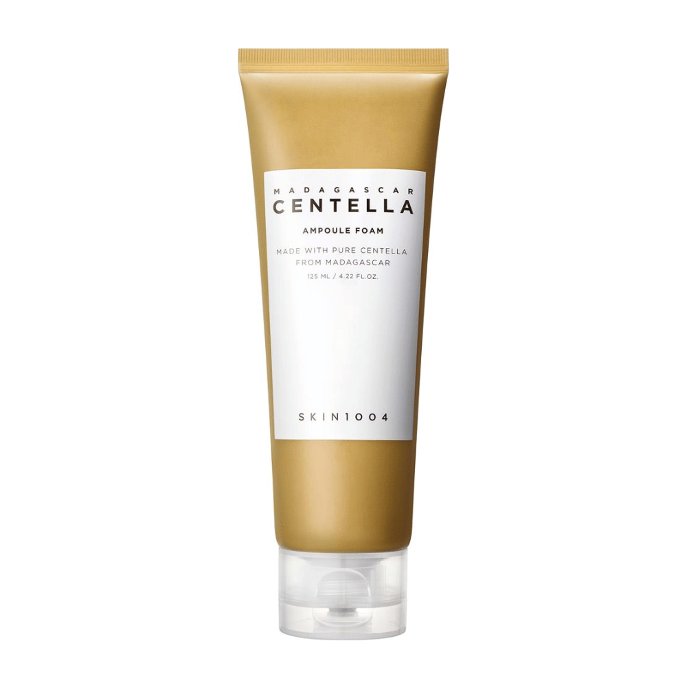 Obrázok zobrazuje tubu "Madagascar Centella Ampoule Foam" od značky SKIN1004. Je to čistiaci produkt na tvár, ktorý obsahuje 125 ml / 4.22 fl.oz. Formula je založená na čistej Centelle extrahovanej z rastlín na Madagaskare. Produkt je navrhnutý tak, aby jemne čistil a ošetroval pokožku.