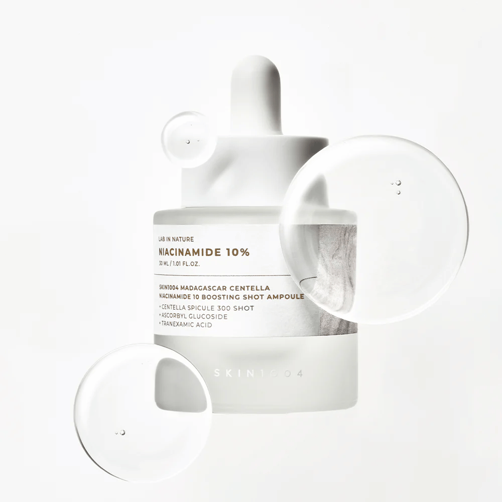 SKIN1004 Madagascar Centella Niacinamide 10 Boosting Shot Ampoule so sérovými kvapkami, ktoré ukazujú ľahkú, rýchlo vstrebateľnú formulu s niacínamidom, tranexámovou kyselinou a centella.