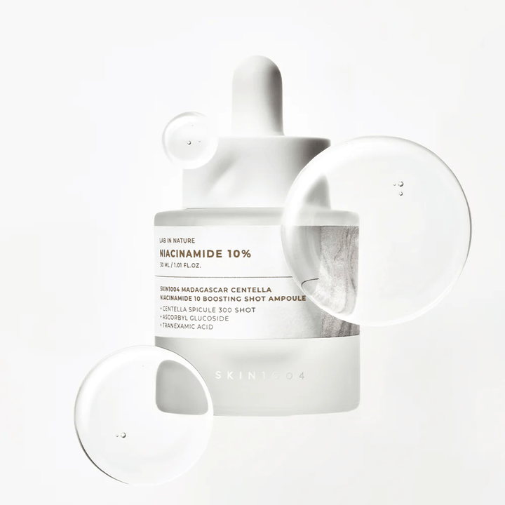 SKIN1004 Madagascar Centella Niacinamide 10 Boosting Shot Ampoule so sérovými kvapkami, ktoré ukazujú ľahkú, rýchlo vstrebateľnú formulu s niacínamidom, tranexámovou kyselinou a centella.