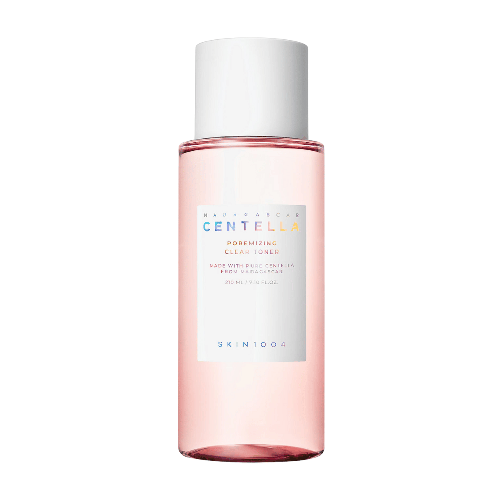 Fľaša s Madagascar Centella Poremizing Clear Toner, ktorá je priehľadná s ružovým odtieňom. Produkt má biely uzáver a etiketu s textom "Poremizing Clear Toner" a "Made with Pure Centella from Madagascar." Fľaša má objem 210 ml a poskytuje pocit sviežosti a starostlivosti o pleť.