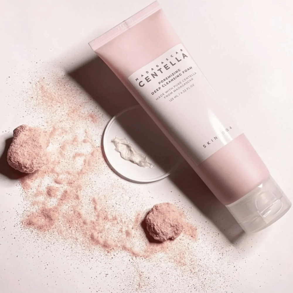 Madagascar Centella Poremizing Deep Cleansing Foam je prezentovaný v ružovej tube. Tuba leží na svetlom podklade spolu s ružovým práškom, ktorý vytvára pocit čistoty a sviežosti. Produkt je navrhnutý na hĺbkové čistenie pokožky pomocou čistej centelly z Madagaskaru.
