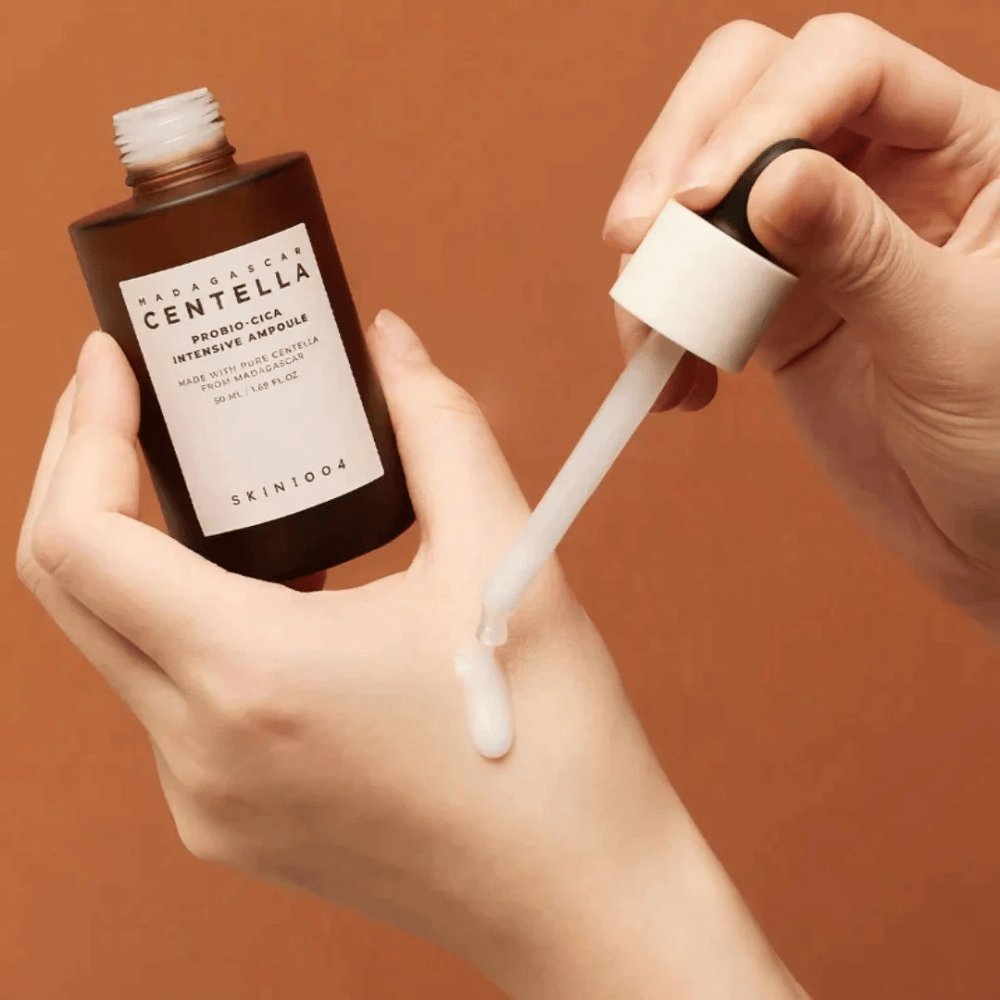 Ruky používajú kvapkadlo na dávkovanie "Madagascar Centella Probio-Cica Intensive Ampoule" od SKIN1004.