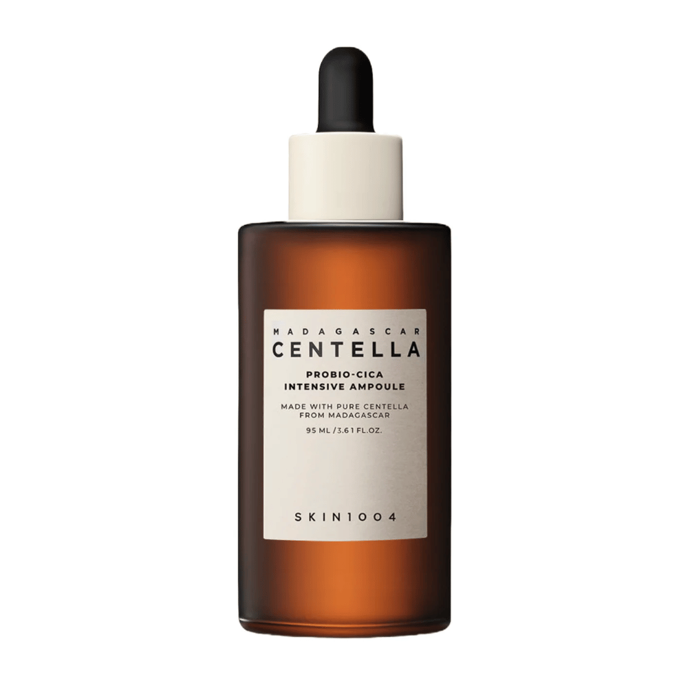 Hnedá sklenená fľaša s kvapkadlom od SKIN1004 Madagascar Centella Probio-Cica Intensive Ampoule na jednofarebnom pozadí.
