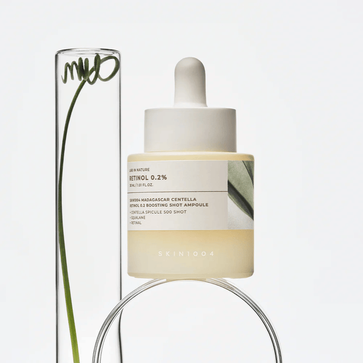 SKIN1004 Madagascar Centella Retinol 0.2 Boosting Shot Ampoule na životnom obrázku s botanickými prvkami – pleťové sérum, ktoré podporuje obnovu pokožky a posilňuje jej ochrannú bariéru.