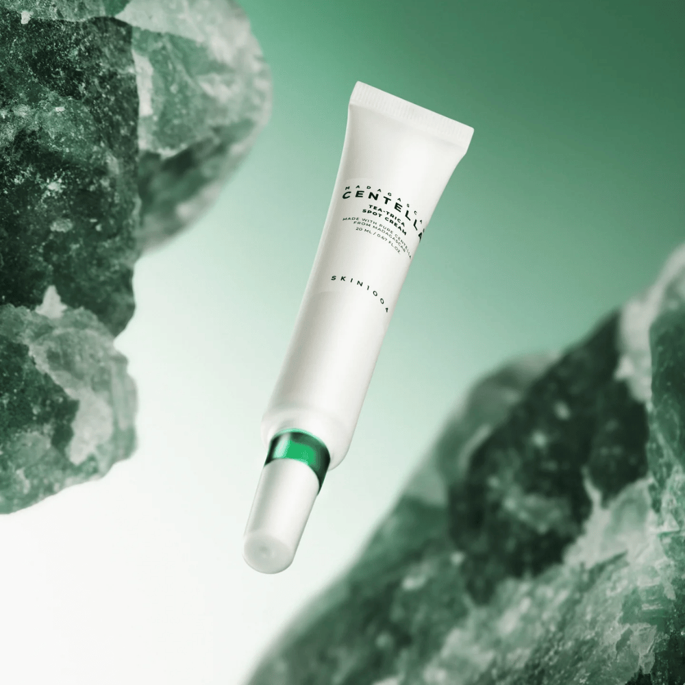 SKIN1004 Madagascar Centella Tea-Trica Spot Cream 20 ml proti akné a vyrážkam, produktový obrázok so zeleným pozadím a kryštálovou štruktúrou – upokojujúci spot treatment s centella asiatica a tea tree.