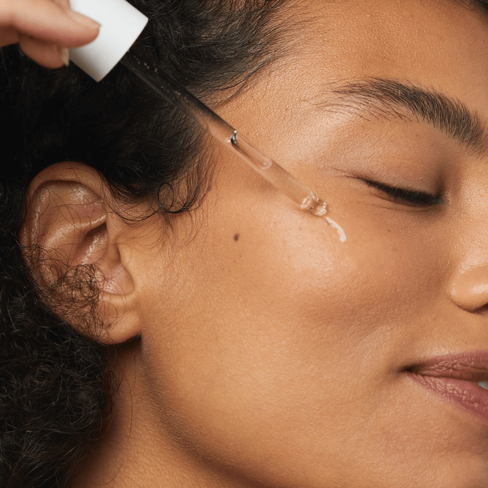 Žena aplikuje Skin1004 Madagascar Centella Hyalu-Cica First Ampoule na líce pipetou.