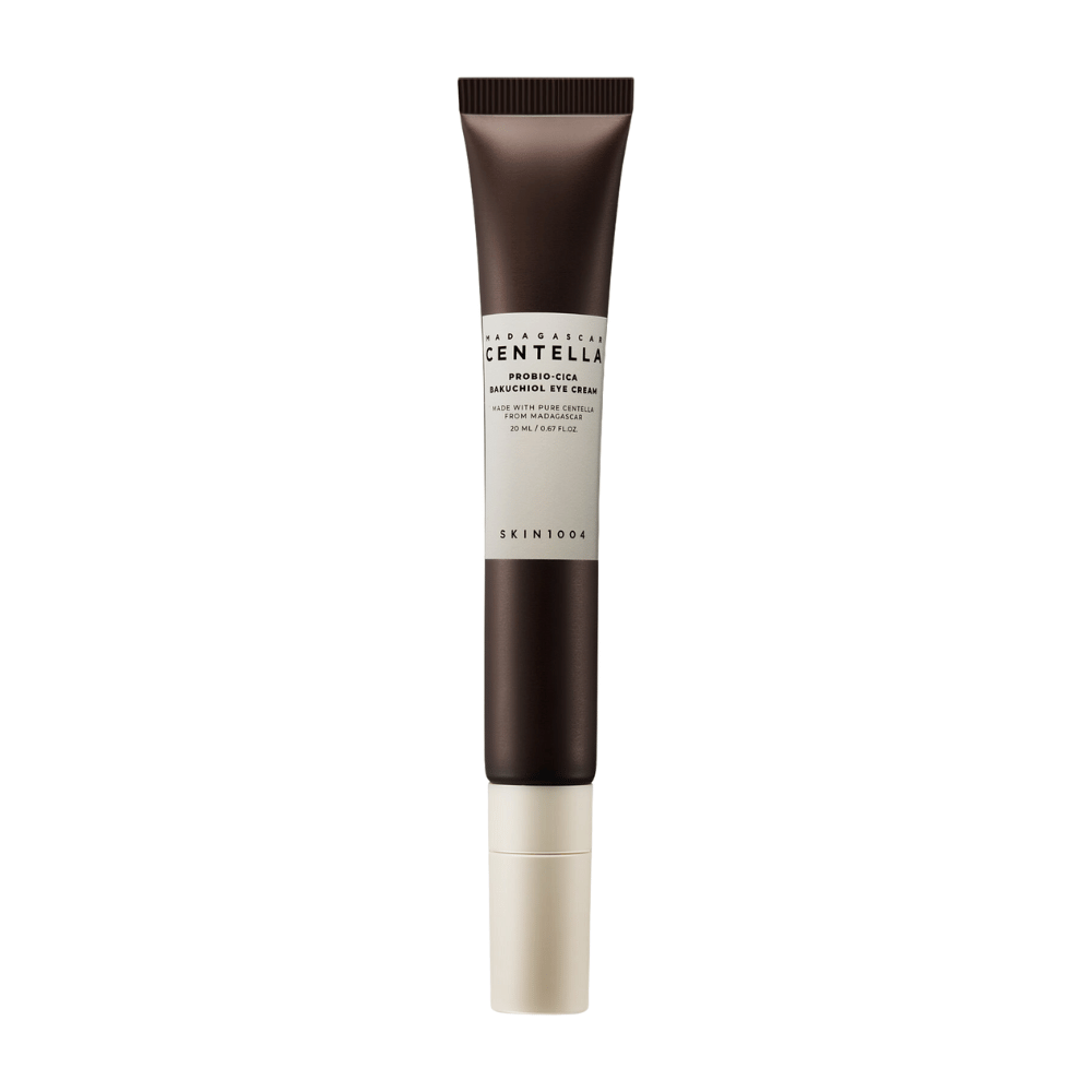 Tuba "Madagascar Centella Probio-Cica Bakuchiol Eye Cream" od SKIN1004. Produkt je navrhnutý pre oblasť očí a obsahuje ingrediencie ako centella z Madagaskaru a bakuchiol, známe pre svoje starostlivosť o pleť a hydratačné vlastnosti. Tuba je elegantná s tmavohnedou farbou prechádzajúcou do bielej.