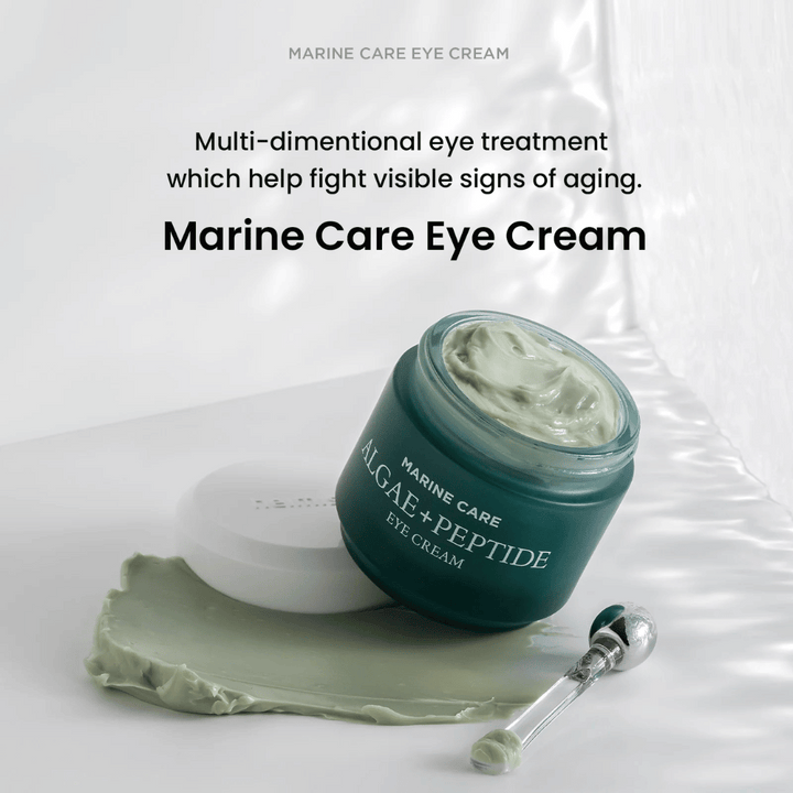 Heimish Marine Care Algae + Peptide Eye Cream v otvorenej nádobe so zelenkastým krémom. Krém je rozotretý vedľa nádoby a aplikátor leží vedľa. Produkt bojuje proti známkam starnutia a poskytuje intenzívnu hydratáciu.
