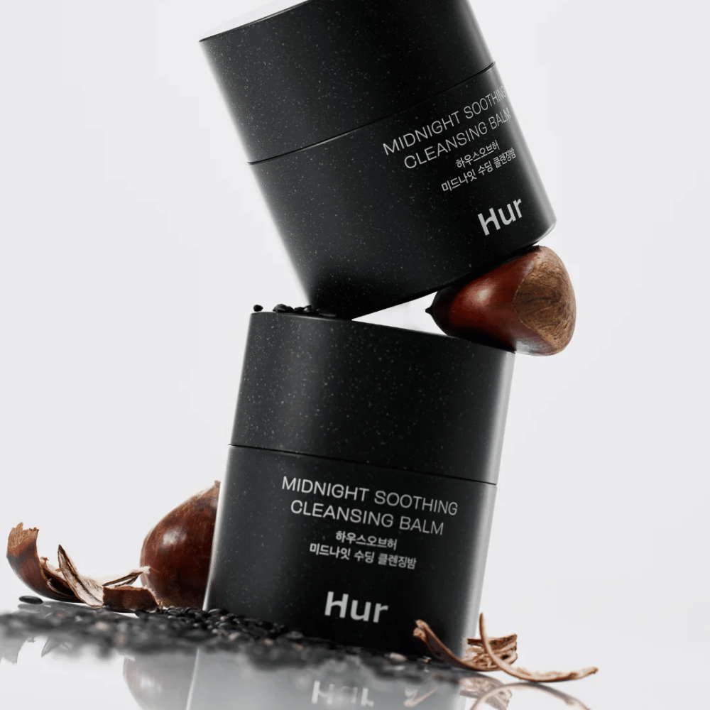 Dve nádoby Ako Midnight Soothing Cleansing Balm naskladané s prírodnými ingredienciami. Výživný čistiaci balzam na každodenné čistenie citlivej pokožky.