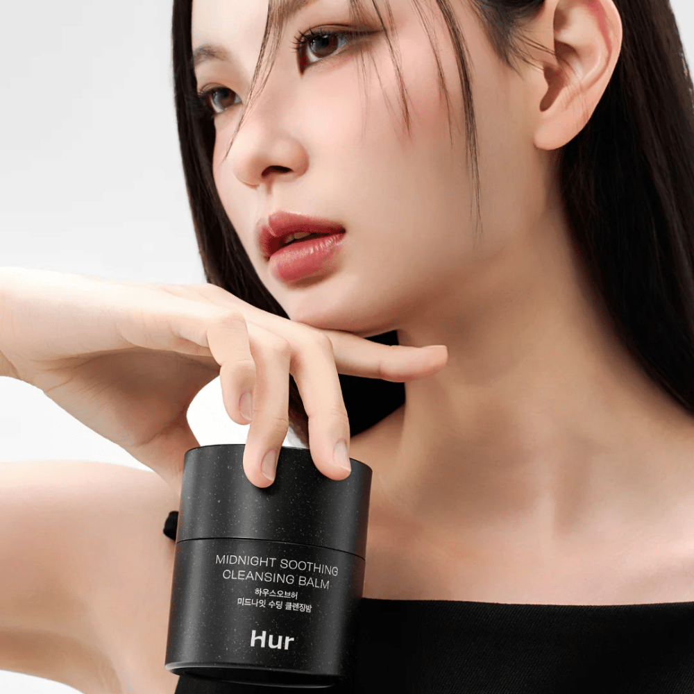 Model drží Ako Midnight Soothing Cleansing Balm. Kórejský čistiaci balzam, ktorý efektívne odstraňuje make-up a čistí pokožku bez podráždenia.