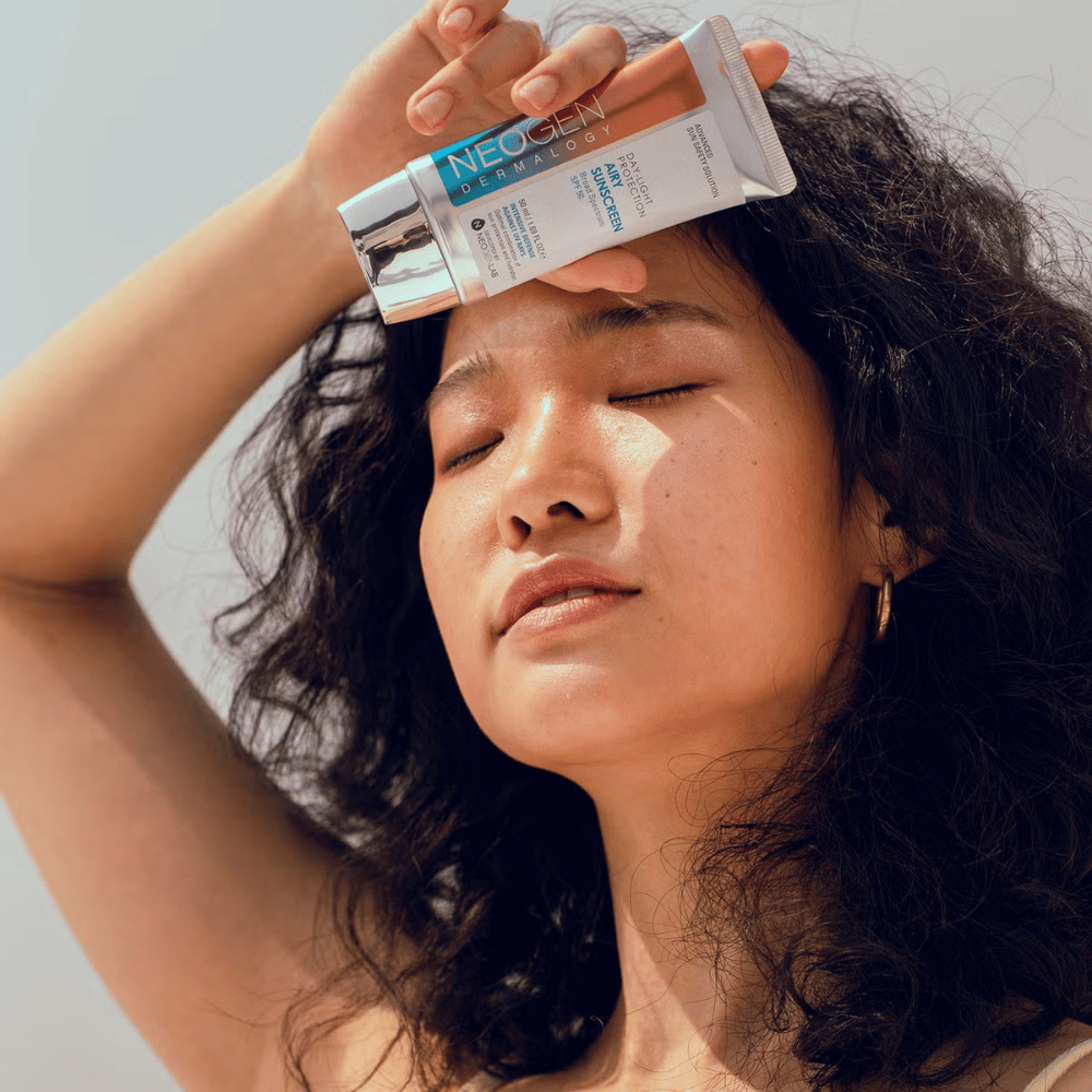 Neogen Dermalogy Day-Light Protection Airy Sunscreen SPF50 50ml – ľahký opaľovací krém so širokospektrálnou UV ochranou, ukázaný pri použití na slnku.