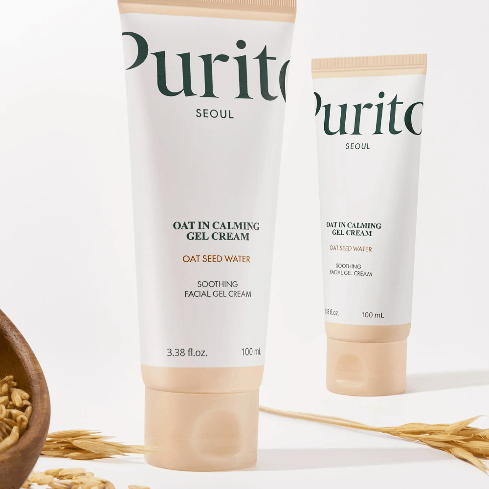 Purito Oat-In Calming Gel Cream v béžovej tube, umiestnený s ovsenými zrnami. Upokojuje citlivú pokožku s ovsenou vodou a ľahkou gélovou textúrou.