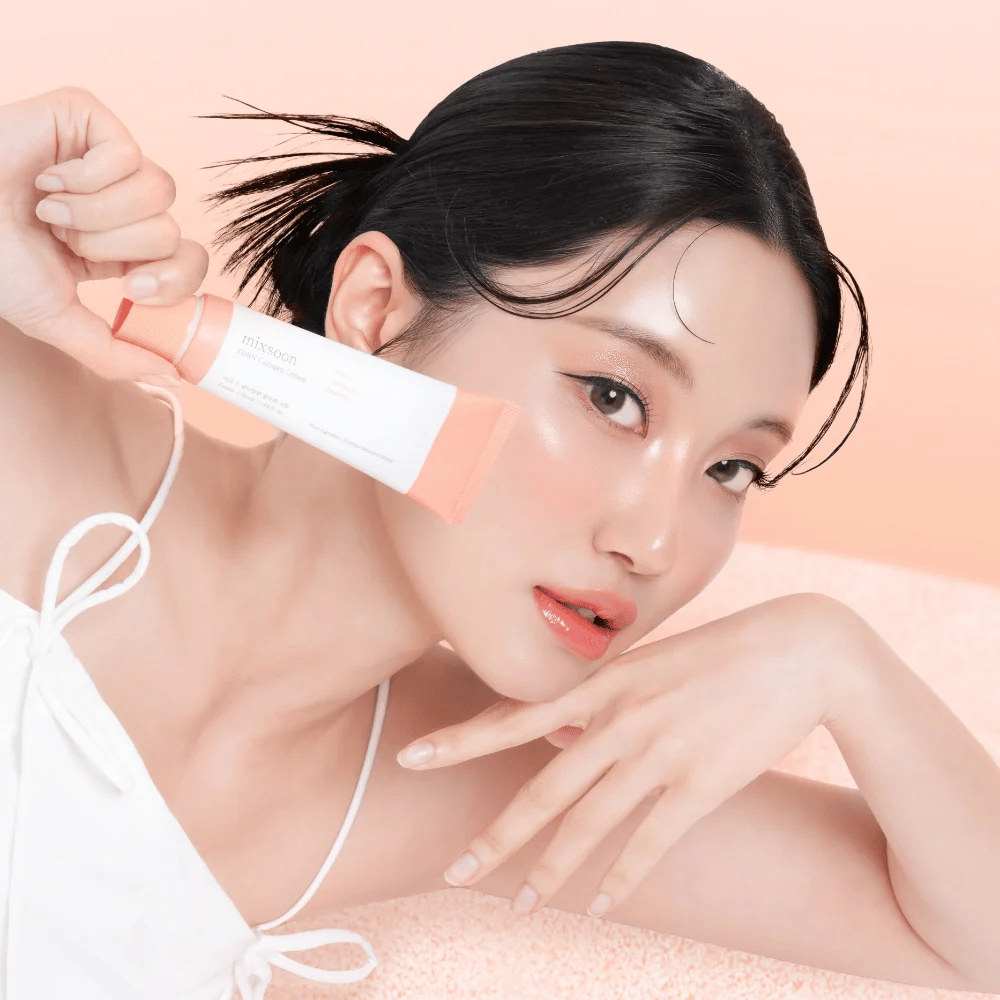 Osoba so žiarivou pokožkou drží Mixsoon PDRN Collagen Cream blízko líca. Krém hydratuje, posilňuje elasticitu a dodáva svieži lesk.