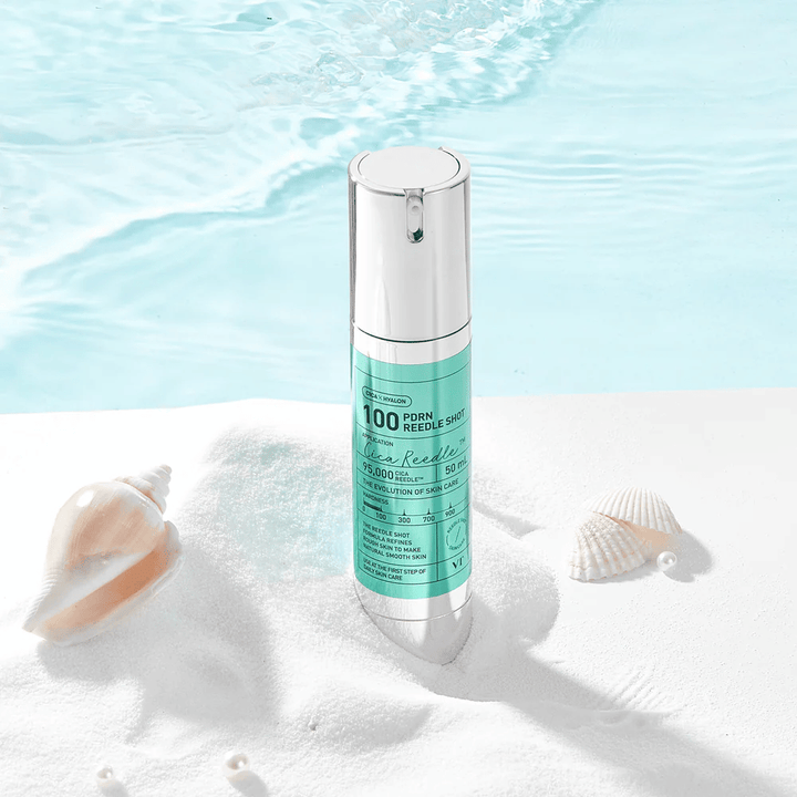 VT Cosmetics PDRN Reedle Shot 100 produkt umiestnený v pieskovom prostredí s morskou tematikou, ktorý symbolizuje hydratáciu, upokojujúci účinok a zlepšenie pokožky
