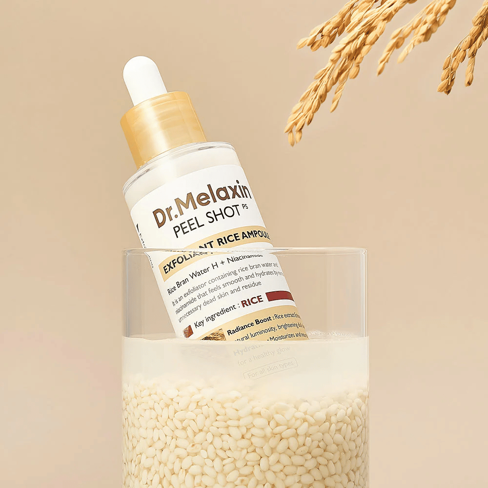 Dr.Melaxin Peel Shot Exfoliant Rice Ampoule umiestnená v pohári s ryžou, ilustruje rozjasňujúce a hydratačné vlastnosti ryžového extraktu v kórejskej starostlivosti o pleť.