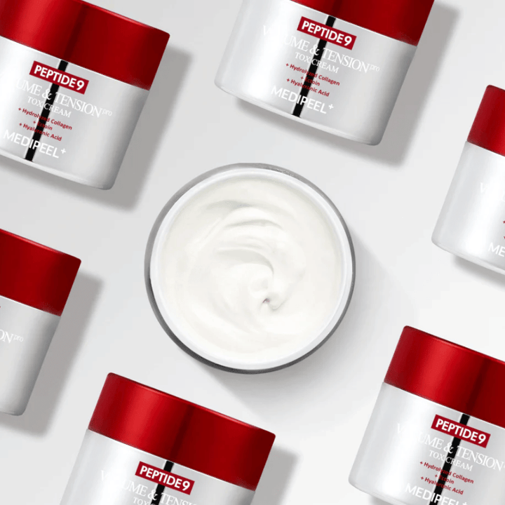 Niekoľko nádob MEDI-PEEL Peptide 9 Volume & Tension Tox Cream usporiadaných na bielom pozadí. Produkt intenzívne hydratuje a dodáva pokožke objem a žiarivosť.
