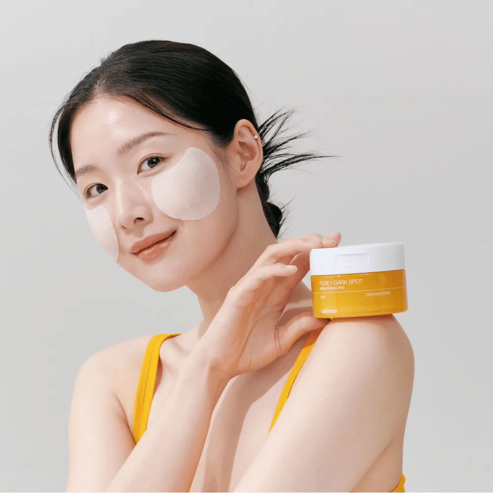Žena aplikuje Celimax Pore + Dark Spot Brightening Pad – kórejské tampóny, ktoré vyrovnávajú tón pleti a znižujú póry a pigmentové škvrny.