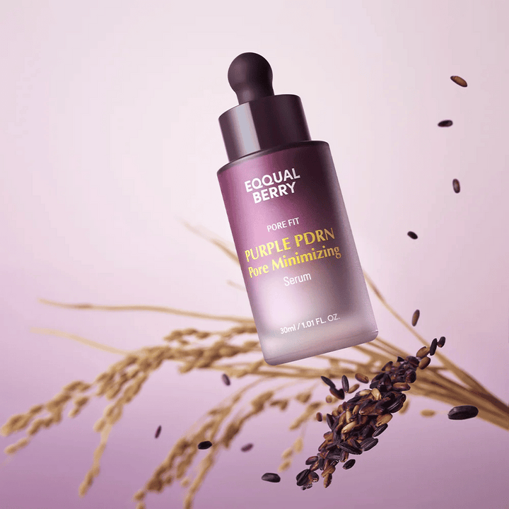 Fľaša s Equal Berry Purple PDRN Pore Minimizing Serum sa vznáša na fialovom pozadí, obklopená čiernou ryžou a ryžovými steblami.