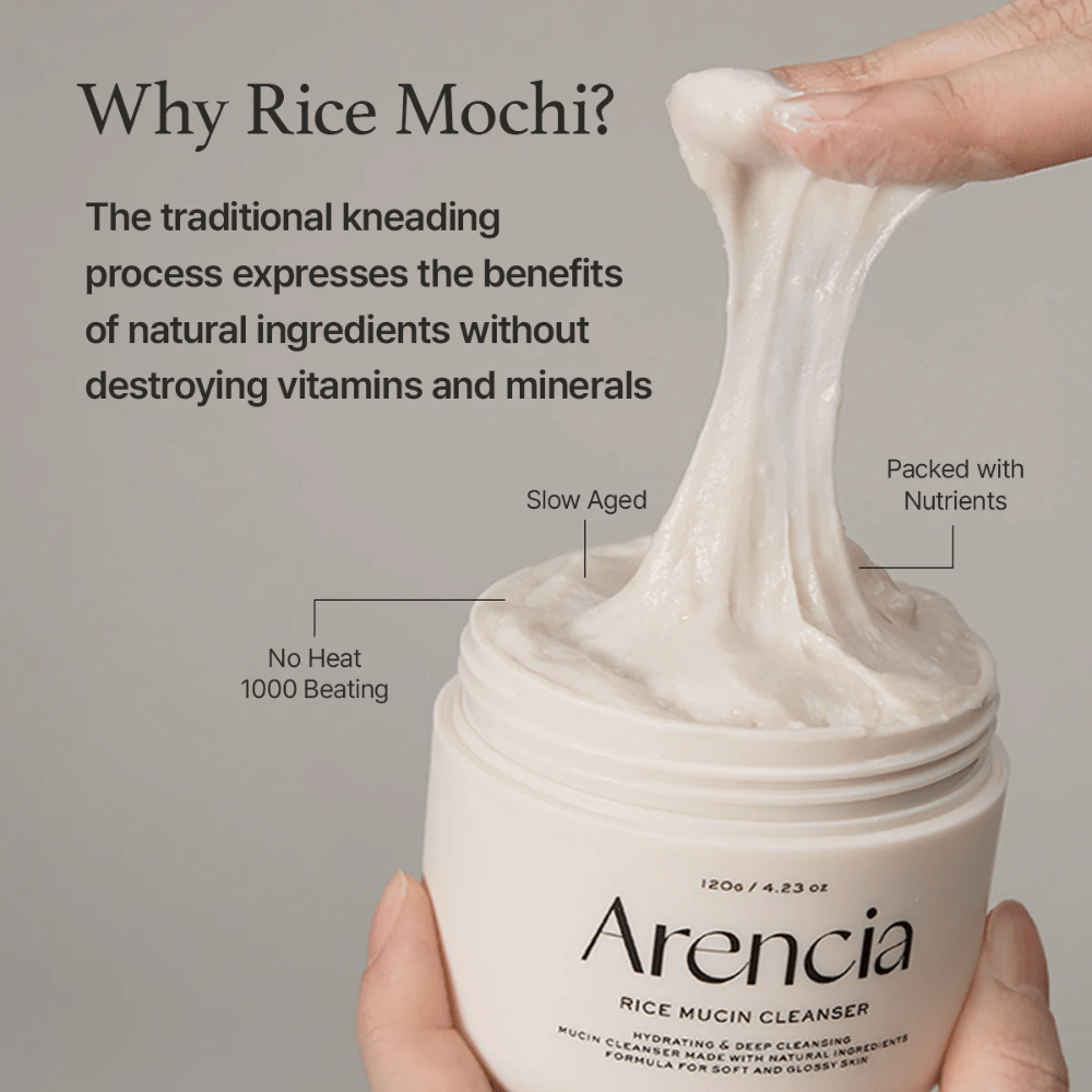Ruka, ktorá vyťahuje elastický, biely čistiaci krém z nádoby označenej "Arencia Rice Mucin Cleanser". Text opisuje tradičné hnetenie, ktoré zachováva živiny bez poškodenia vitamínov a minerálov.