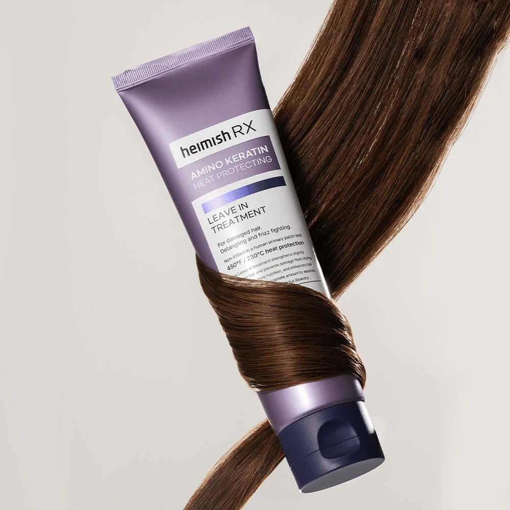Heimish RX Amino Keratin Leave-In Treatment – výživná tepelne ochranná starostlivosť o vlasy obklopená lesklými vlasmi, symbolizuje posilňujúci a hydratačný účinok pre poškodené vlasy.
