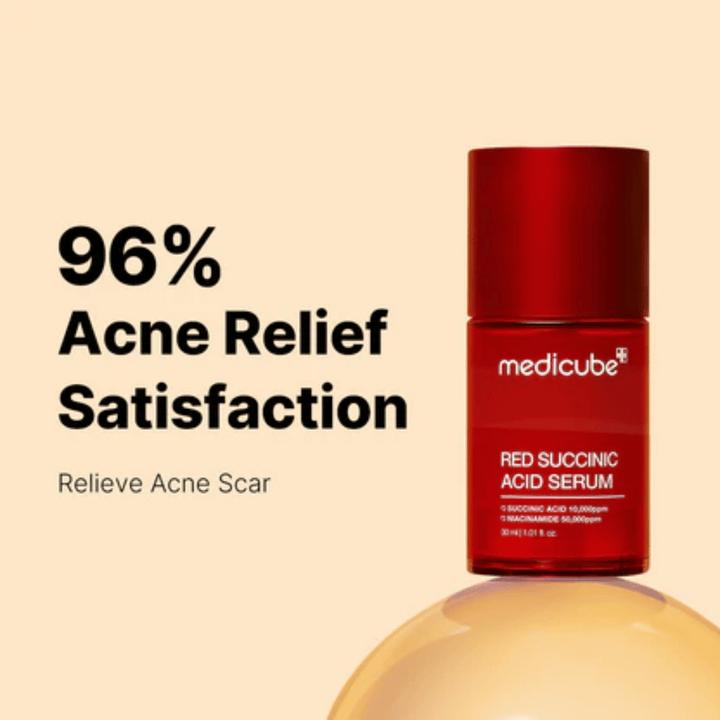 Medicube Red Succinic Acid Serum v červenej pumpovacej fľaši, zobrazené na béžovom pozadí s textom „96% Acne Relief Satisfaction“. Produkt je vyvinutý na zníženie jaziev po akné a upokojenie pokožky.