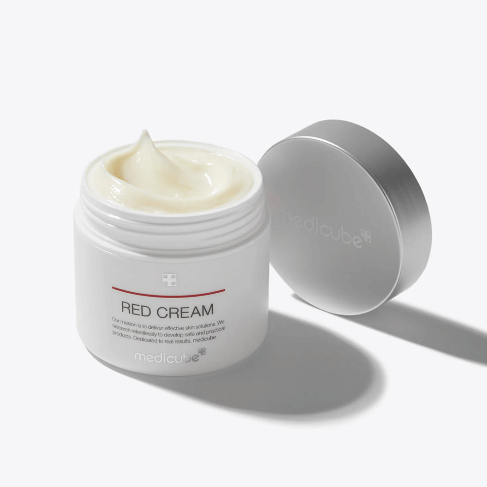 Otvorená nádoba s medicube Red Cream 50ml – svetložltý pleťový krém v bielom obale so strieborným viečkom, vyvinutý pre pleť náchylnú na akné.