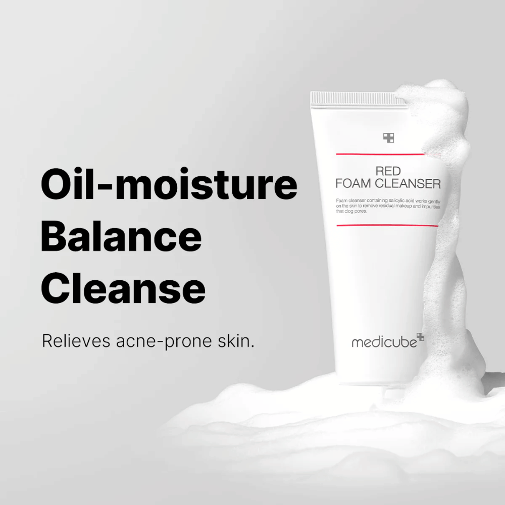 Tuba Medicube Red Foam Cleanser stojí vzpriamene medzi penou. Text "Oil-moisture Balance Cleanse" je zobrazený vľavo, s popisom "Zmierňuje pleť náchylnú na akné" pod ním. Pozadie je svetlosivé.