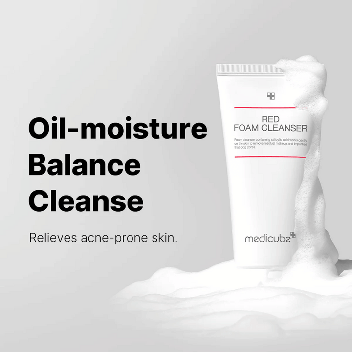 Tuba Medicube Red Foam Cleanser stojí vzpriamene medzi penou. Text "Oil-moisture Balance Cleanse" je zobrazený vľavo, s popisom "Zmierňuje pleť náchylnú na akné" pod ním. Pozadie je svetlosivé.