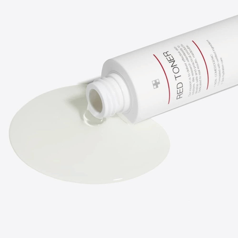 Otvorená fľaša s medicube Red Toner, ktorá sa vylieva na biely povrch – ukazuje ľahkú a tekutú konzistenciu produktu.