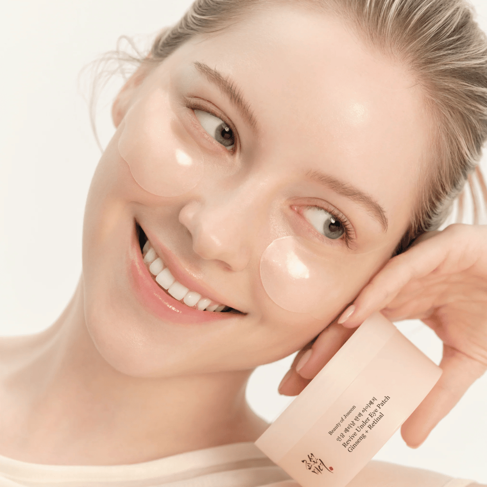 Modelka s Beauty of Joseon under eye patches a produktom v ruke, očné náplasti s ženšenom a retinalom pre sviežejšiu a hladšiu oblasť očí.