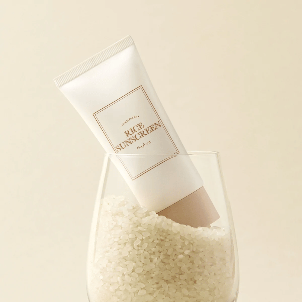 Tuba s "I'm from" Rice Sunscreen, SPF50+ PA++++, umiestnená v pohári s ryžovými zrnami.