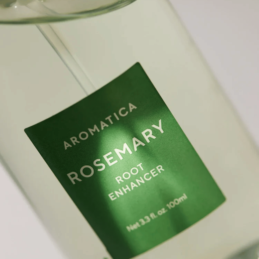 Detailný záber etikety na AROMATICA Rosemary Root Enhancer. Zelená etiketa a transparentná fľaša zvýrazňujú čistý a minimalistický vzhľad produktu.