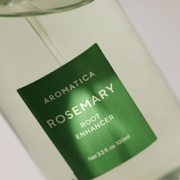 Detailný záber etikety na AROMATICA Rosemary Root Enhancer. Zelená etiketa a transparentná fľaša zvýrazňujú čistý a minimalistický vzhľad produktu.