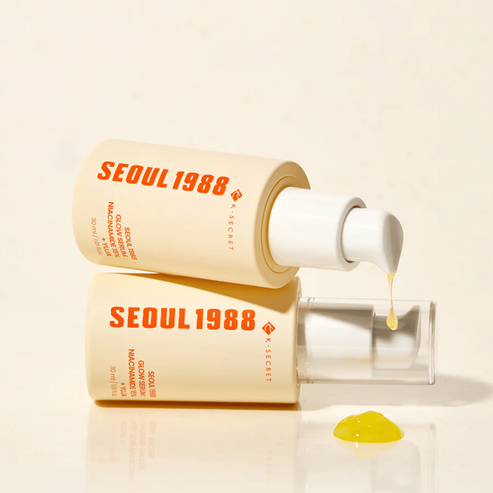 Dve fľaše Seoul 1988 Glow Serum ležiace a stojace, so žltým sérom kvapkajúcim z pumpy.