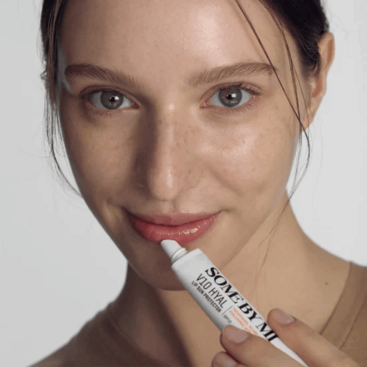 Žena drží tubu V10 Hyal Lip Sun Protector SPF15 7ml balzamu na pery na ochranu pred slnkom a hydratáciu, od SOME BY MI.