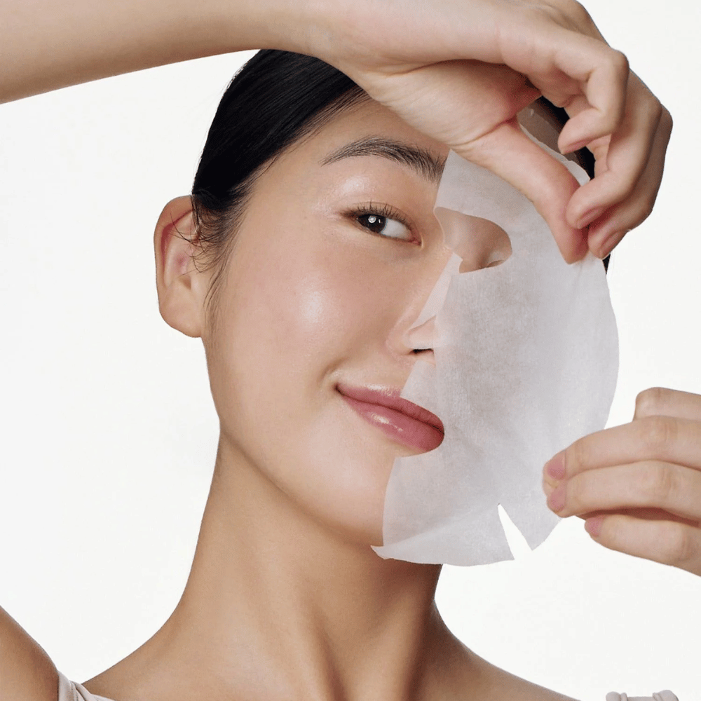 Tento obrázok zobrazuje osobu používajúcu pleťovú masku, konkrétne "Galactomyces Glutathione Daily Mask" od Some By Mi. Maska rozjasňuje pokožku a dodáva žiarivý lesk, pričom zároveň ošetruje a hlboko hydratuje pleť vďaka ingredienciám ako glutatión a vitamín C.