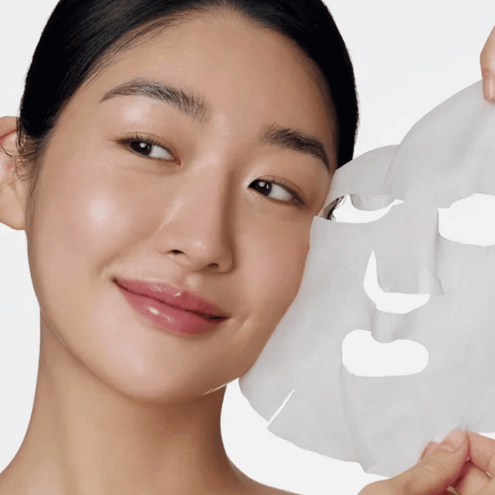 Obrázok zobrazuje osobu používajúcu pleťovú masku, konkrétne "Retinol Intense Daily Mask" od Some By Mi. Maska je navrhnutá pre každodenné použitie a obsahuje retinol na zlepšenie textúry pokožky, zníženie jemných liniek a vytvorenie rovnomernejšieho tónu pleti.