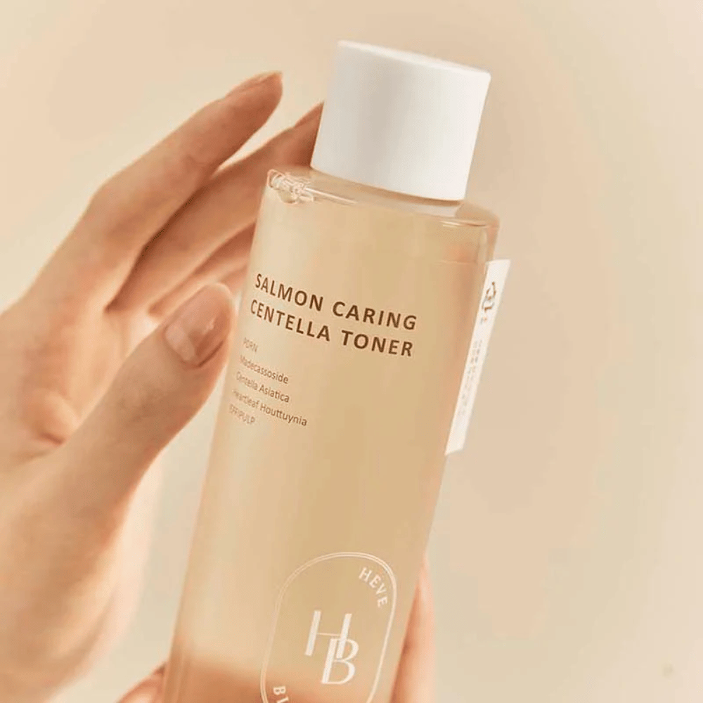 Detailný záber na Salmon Caring Centella Toner v ruke – upokojujúci toner s PDRN a rastlinnými extraktmi, ktoré pomáhajú posilniť pokožku a znižujú pocit podráždenia.