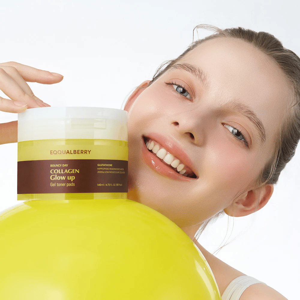 Usmievavá modelka držiaca Bouncy Day Collagen Glow up Gel Toner Pads, ktoré pomáhajú dodávať mladistvý lesk a pevnosť s nízkomolekulárnym kolagénom a glutatiónom.