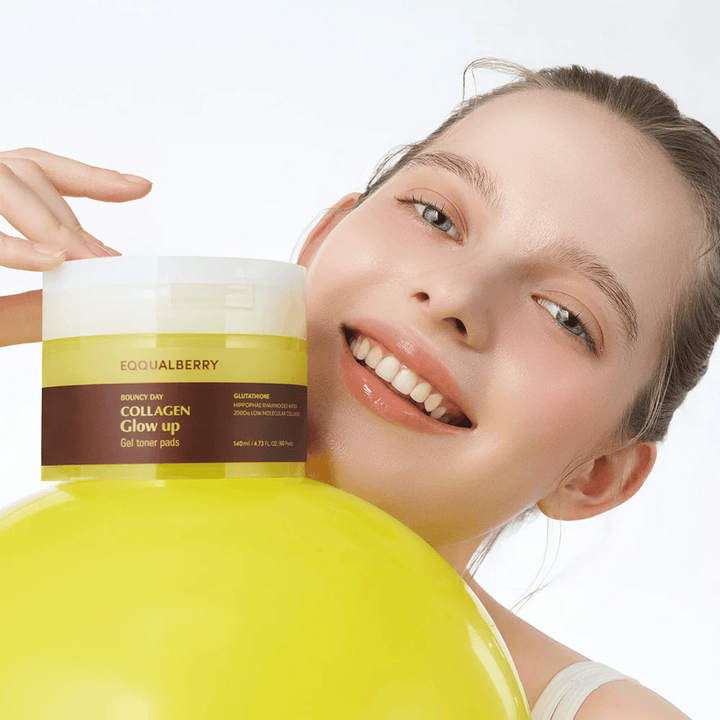 Usmievavá modelka držiaca Bouncy Day Collagen Glow up Gel Toner Pads, ktoré pomáhajú dodávať mladistvý lesk a pevnosť s nízkomolekulárnym kolagénom a glutatiónom.