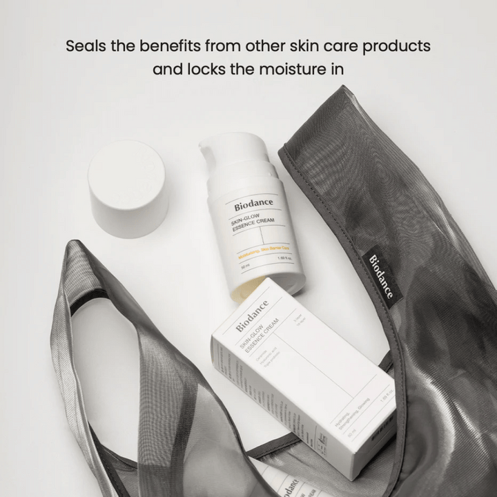 Biodance Skin-Glow Essence Cream stojaci v popredí spolu s obalom produktu a čiernou priehľadnou kozmetickou taškou, s textom nad tým, ktorý zdôrazňuje schopnosť krému uzavrieť vlhkosť a posilniť účinok iných produktov starostlivosti o pleť.